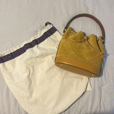 Brand New Slightly Used Tory Burch Bucket Bag. Color Is A True Mustard Yellow In A Suede Fabric Elegant Yellow Bucket Bag With Top Handle, Elegant Yellow Top Handle Bucket Bag, Elegant Yellow Bucket Bag With Removable Pouch, Elegant Yellow Bucket Bag With Adjustable Strap, Elegant Yellow Bucket Bag With Detachable Strap, Elegant Yellow Bucket Bag, Luxury Yellow Bucket Bag With Removable Pouch, Elegant Yellow Bucket Bag For Travel, Elegant Monogram Canvas Bucket Bag