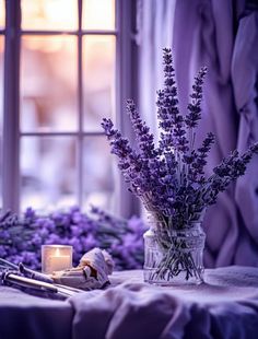 lavender flowers in a vase next to a candle