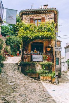 an old stone building with ivy growing on it's roof and balcony above the entrance