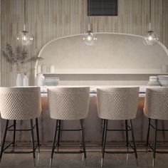 four stools are lined up in front of a counter with plates and bowls on it