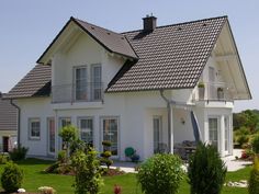 a large white house sitting on top of a lush green field