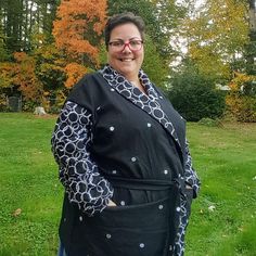 a woman standing in the grass wearing an apron