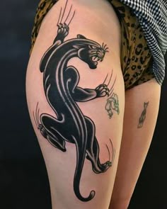 a woman's thigh with a black and white tattoo on it