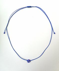 Evil eye choker necklace, String choker, Minimalist The evil eye is used to protect the person that wears it from the malevolent look of others who envy or dislike that person. The necklace is made with 1mm black waxed string,and has a 8mm blue glass evil eye bead. At the end it is adorned with seed beads. Total length: 80cm / 31 inches It is adjustable to fit a lot of sizes. Custom orders for different colour combinations are welcome. Other necklaces in my shop: https://www.etsy.com/shop/LuckyR Festival Jewelry With Adjustable Nylon Cord, Festival Jewelry With Sliding Knot On Nylon Cord, Adjustable Knot Nylon Cord Jewelry For Festival, Evil Eye Choker Necklace As Gift, Evil Eye Choker Necklace For Gift, Minimalist Blue Jewelry With Adjustable Cord, Blue Necklace With Adjustable Waxed Cord, Blue Necklaces With Adjustable Cord, Blue Adjustable Amulet Necklace