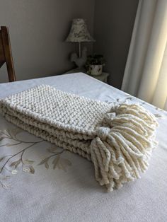 a white blanket laying on top of a bed