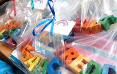 plastic bags filled with colorful wooden letters on top of a table