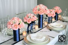 the table is set with pink flowers and candles