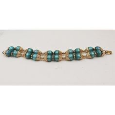 This is part of Chairish’s Costume Jewelry assortment.  1950s goldtone filigree with green resin moonglow beaded two strand bracelet with fold over clasp. Marked "Napier." Measures: 8 5/8 inches long by 15/16 inches wide. Condition: Very good; some wear to jump rings connecting two strands, otherwise great. The matching clip earrings are also available.  Please reference the measurements noted in the description above for the best approximate dimensions. Please reach out to the seller under "Ask Vintage Turquoise Round Bead Bracelets, Formal Vintage Beaded Bracelets With Round Beads, Vintage Turquoise Beaded Bracelets, Vintage Beaded Bracelets For Formal Occasions, Vintage Blue Beaded Bracelets, Vintage Gold Beaded Bracelets For Gift, Vintage Green Beaded Bracelets, Vintage Green Round Bead Bracelets, Vintage Green Round Beads Bracelet