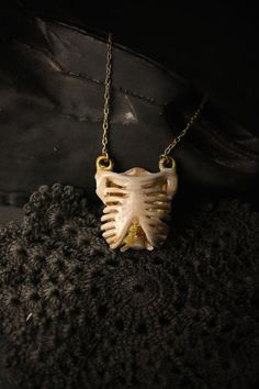 ** Unique Human Rib Cage Charm Necklace / Hand - Painting Version- Original Design and Made by Defy ** Another cool item in our Human Anatomy collection. The pendant is made of brass material with gold-plated chain. The skull has nice handmade details in color hand paint tones. Product info ; - The Human Rib Cage Dimensions are : approx. 2.7 x 2.9 x 1.2 cm. - Necklace chain length : please choose our length options - Material : brass (nickel free) - Claw Clasp **Shipping to World Wide** - Please White Gothic Necklace Gift, Gothic Brass Jewelry Gift, Handmade Gothic White Jewelry, Handmade Gothic Gold Jewelry, Bohemian Gold Jewelry For Halloween, Unique Halloween Gift Necklaces, Unique Bone-colored Brass Jewelry, Unique Necklaces For Halloween Gift, Bone Colored Metal Jewelry Gift