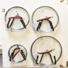 four pairs of scissors are in the middle of three circular holders with hooks on them