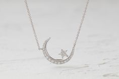 This bright crescent moon features a shining star sitting on its edge. The pave round set diamond adds a gleaming touch. The length is also adjustable, which makes it perfect for layering. Celestial White Gold Diamond Necklace For Anniversary, Silver Half Moon Diamond Jewelry, Celestial Style White Gold Diamond Necklace, Celestial White Gold Diamond Necklace, Moon-shaped Single Cut Diamond Jewelry, Moon Shaped Single Cut Diamond Jewelry, Celestial White Gold Diamond Necklace With Diamond Accents, Celestial Style Round Diamond Necklace In White Gold, White Gold Crescent Diamond Necklace For Gift