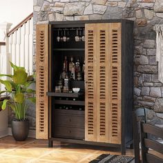 a wooden cabinet with wine glasses and bottles in it next to a potted plant