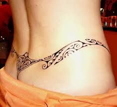 a woman's stomach with a tattoo design on the lower part of her belly