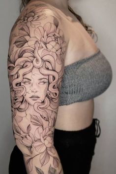 a woman's arm with flowers on it and a face in the middle of her arm