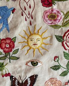 embroidered fabric with flowers, birds and sun in the center on white background for use as wall hanging