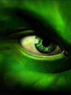 an eye with green eyeshade and long eyelashes is seen in this artistic photograph