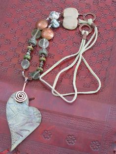 Raku heart pendant and beadwork, seaglass bead, porcelain, freshwater pear and copper beads finished with green suede.  Earring are copper and green suede to match. Fringe Necklace, Suede Fringe, Green Suede, Philadelphia Pa, Jewelry Plate, Heart Pendant, Bead Work, Washer Necklace, Philadelphia