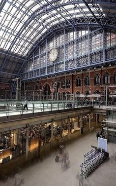 the inside of a train station with people walking around