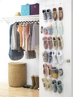 an organized closet with shoes and clothes hanging on the wall, next to a basket