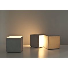 two cube shaped lamps sitting next to each other on a white surface with light coming from them