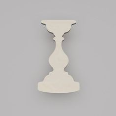 a white wooden candle holder on a gray background with space for text or image to be added