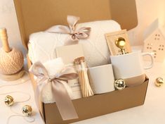 a gift box filled with toiletries, candles and other items on a white table