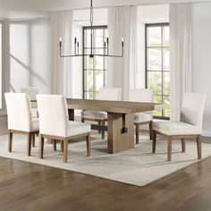 a dining room table with white chairs around it