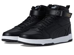 PUMA RBD Game - Men's Shoes : Puma Black/Puma Black/Puma Team Gold : Add some retro flair to their wardrobe by adding the PUMA RBD Game sneakers. Leather and synthetic upper. Mesh fabric lining. Removable textile insole. Molded midsole. SoftFoam footbed. Lace-up vamp with hook-and-loop strap closure. Round perforated toe. Pull tab on the heel for easy wear. Branding detail on the tongue and heel. Synthetic treaded sole. Imported. Measurements: Weight: 1 lb Product measurements were taken using s Functional High-top Synthetic Skate Shoes, Synthetic High-top Sneakers With Elastic Laces, High-top Synthetic Sneakers With Elastic Laces, Sporty High-top Sneakers With Removable Insole For Streetwear, Cushioned High-top Synthetic Sneakers For Jogging, Casual Basketball Shoes With Removable Insole, Cushioned Synthetic High-top Sneakers For Jogging, Cushioned High-top Sneakers For Jogging, Synthetic High-top Sneakers With Elastic Laces For Streetwear