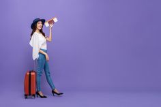 a young woman holding a toothbrush and standing next to a suitcase on a purple background