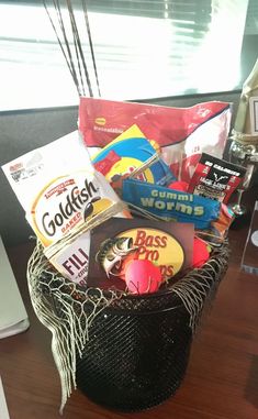 a basket filled with candy and snacks on top of a desk