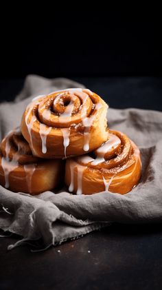 cinnamon rolls with icing sitting on top of a cloth