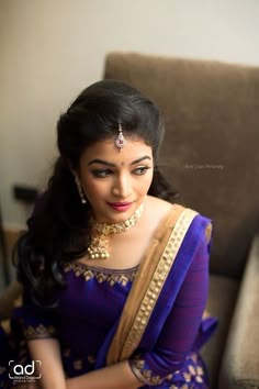 a woman in a blue sari sitting on a couch