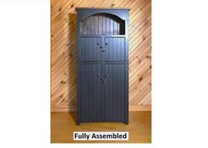 a tall wooden cabinet sitting on top of a hard wood floor next to a wall