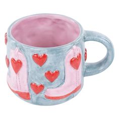 a ceramic mug with hearts painted on it