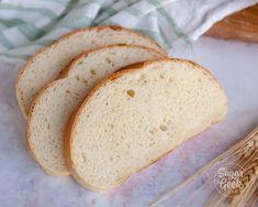 three slices of bread sitting on top of a table next to oats and a whisk