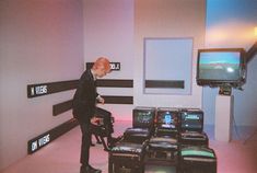 a man in a suit and tie standing next to a bunch of televisions on display