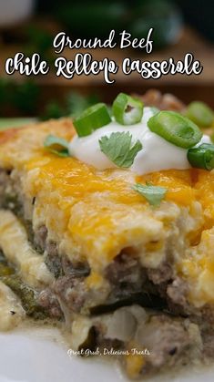 a white plate topped with a slice of ground beef and cheese casserole covered in sour cream