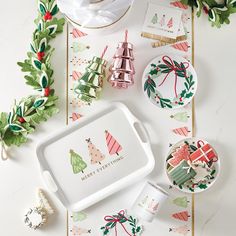 a tray with christmas decorations on it and other holiday items around the tray, along with holly wreaths