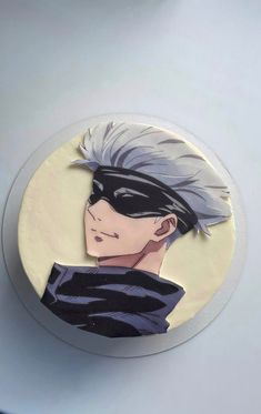 a close up of a cake on a table with a drawing of a person wearing a mask