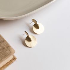 These brass earrings have a minimalist design perfect for architecture lovers. The design cosist of the intersection of a disc and a half disc. Its geometric shape is inspired by the Bauhaus movement and Moholy Nagy's paintings. Like all my jewelry, these earrings have been designed and manufactured by me in my Madrid workshop. The material of the earrings is brass with matte finish, but the post and the ear back are made of silver to avoid problems of allergic reactions. MATERIALS and FINISHES Minimalist Round Metal Earrings, Modern Round Brass Earrings, Minimalist Round Brass Earrings, Minimalist Circle Earrings As Gift, Minimalist Round Disc Earrings, Modern Nickel-free Round Disc Earrings, Minimalist Circle Brass Earrings, Minimalist Nickel-free Circular Earrings, Minimalist Nickel-free Circle Earrings