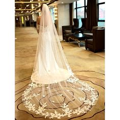 a woman in a wedding dress is standing on the floor with her veil over her head