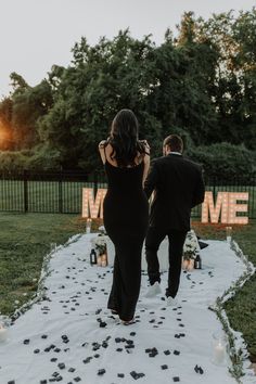 the bride and groom are walking down the aisle at their outdoor wedding ceremony with candles lit