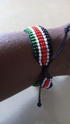 a person's arm is adorned with multicolored beaded bracelets and beads