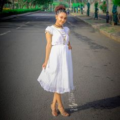 This exquisite Habesha dress is a true masterpiece of Ethiopian fashion. The dress is made from the finest handwoven Menen fabric, which is known for its softness, durability, and luxurious feel. The fabric is carefully crafted by skilled artisans using traditional weaving techniques that have been passed down through generations. The dress is a beautiful shade of white, which adds to its timeless elegance and sophistication. The simple yet stunning design of the dress allows the beauty of the f Ethiopian Fashion, Eritrean Dress, Habesha Dress, Habesha Kemis, Traditional Weaving, Shades Of White, Weaving Techniques, Timeless Elegance, The Dress