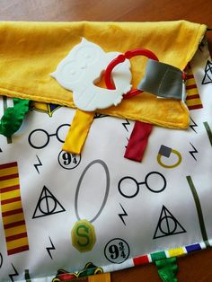 a close up of a bag on a table with harry potter fabric and other items