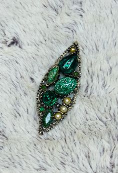 Vintage Schiaparelli or Florenza Faux Pearl Rhinestone Emerald Green Gemstone Murano Dragons Breath Cabochon Brooch Pin  This leaf shaped brooch pin has stunningly beautiful glass gemstones, some of which are called "dragons breath" which are the gorgeous glittery sparkly gems that are seen. The brooch is wrapped in bronze with a spiky unique texture. Closes with a barrel pin.  Very Good Vintage Condition. Only slight wear on the faux pearls; item is pre-owned and may have some signs of light us Green Crystal Brooch Jewelry, Green Rhinestone Wedding Brooch, Green Rhinestone Wedding Brooches, Elegant Green Rhinestone Brooches, Formal Green Rhinestone Brooches, Witchy Hair, Vintage Schiaparelli, Dragons Breath, Green Gemstones