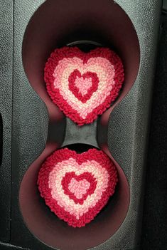 two crocheted hearts are placed in the center of a speaker