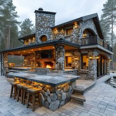 an outdoor kitchen and dining area in the middle of a wooded area with stone steps leading up to it