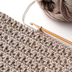 a crochet project with yarn and knitting needles