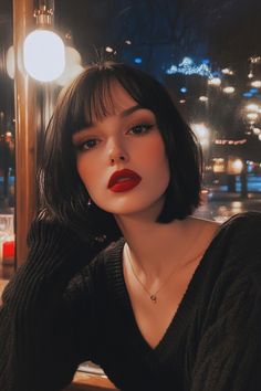 Woman with dark hair and red lipstick sitting in a dimly lit café. Bob Hairstyles Women, Good Curling Irons, Straight Across Bangs, Highlighted Bangs, Classic Bob, Asymmetrical Cut, Bob With Bangs, Hairstyles Women, Long Locks